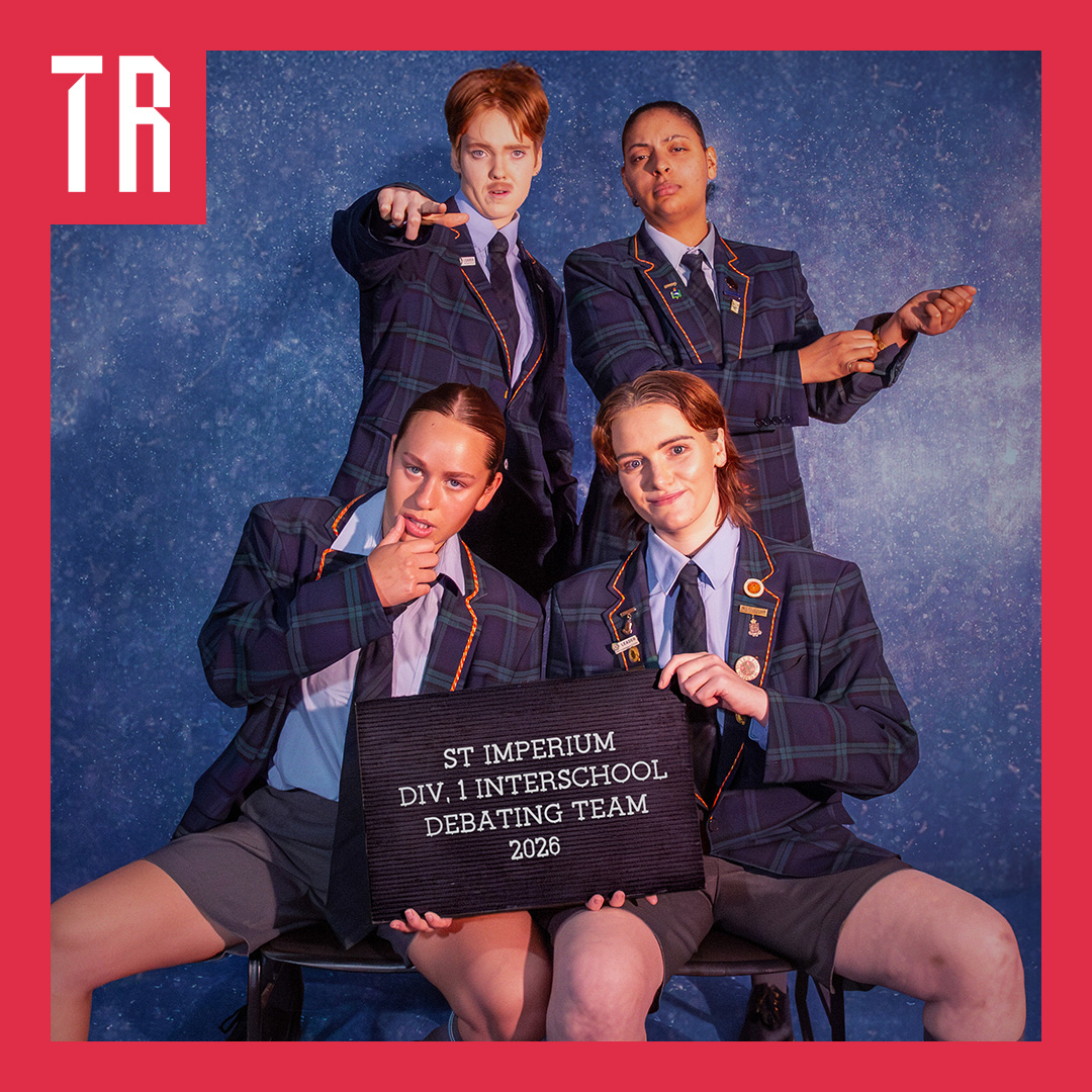Photo: Ben Andrews Four non binary and female actors are dressed as elite private school boys, they pose in a cheeky way behind a signs that says St Ignatius debating team