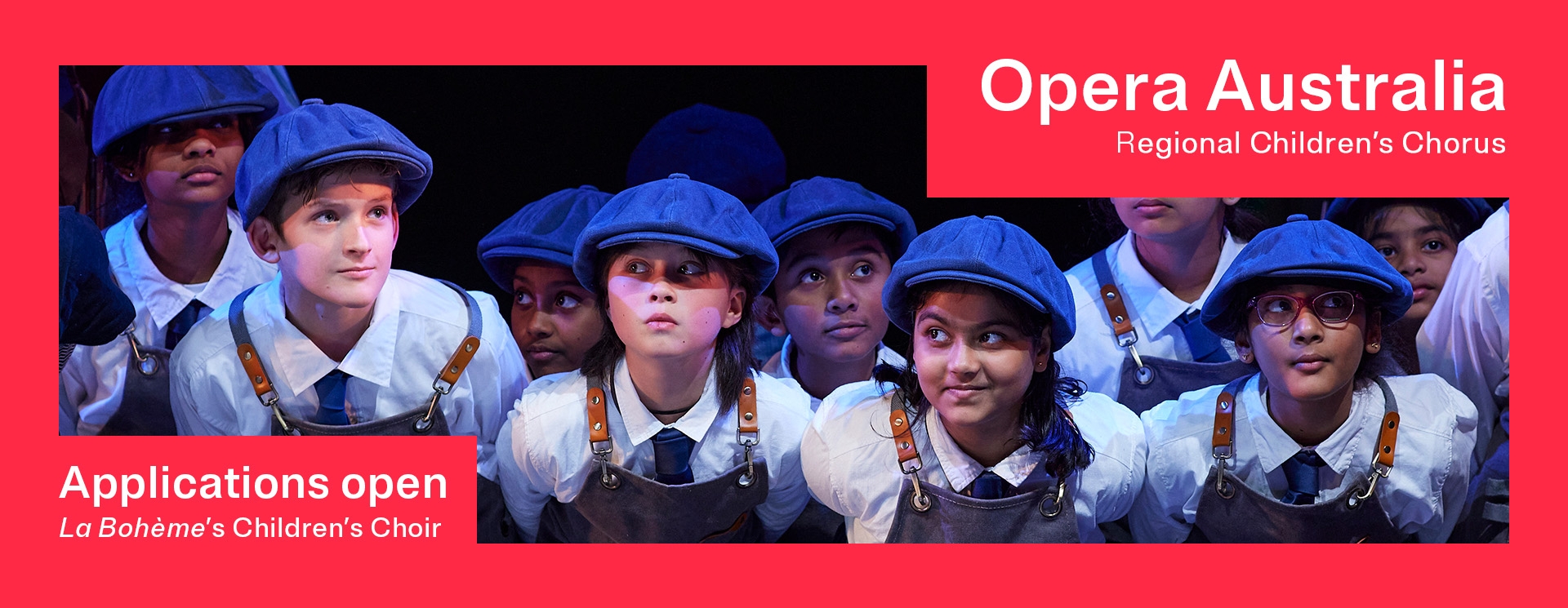 La Bohème childrens chorus banner A group of childfen stand in a cluster performing on stage. They are wearing blue berrets and aprons